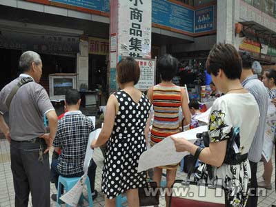 市场内群众边看警示片边看资料