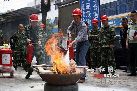 (湖南省涟源市消防大队聂指导员在指导桥头河镇消防队队员使用灭火器灭火。)